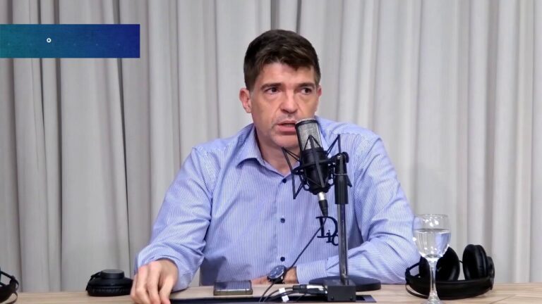 a man sitting at a desk with a microphone