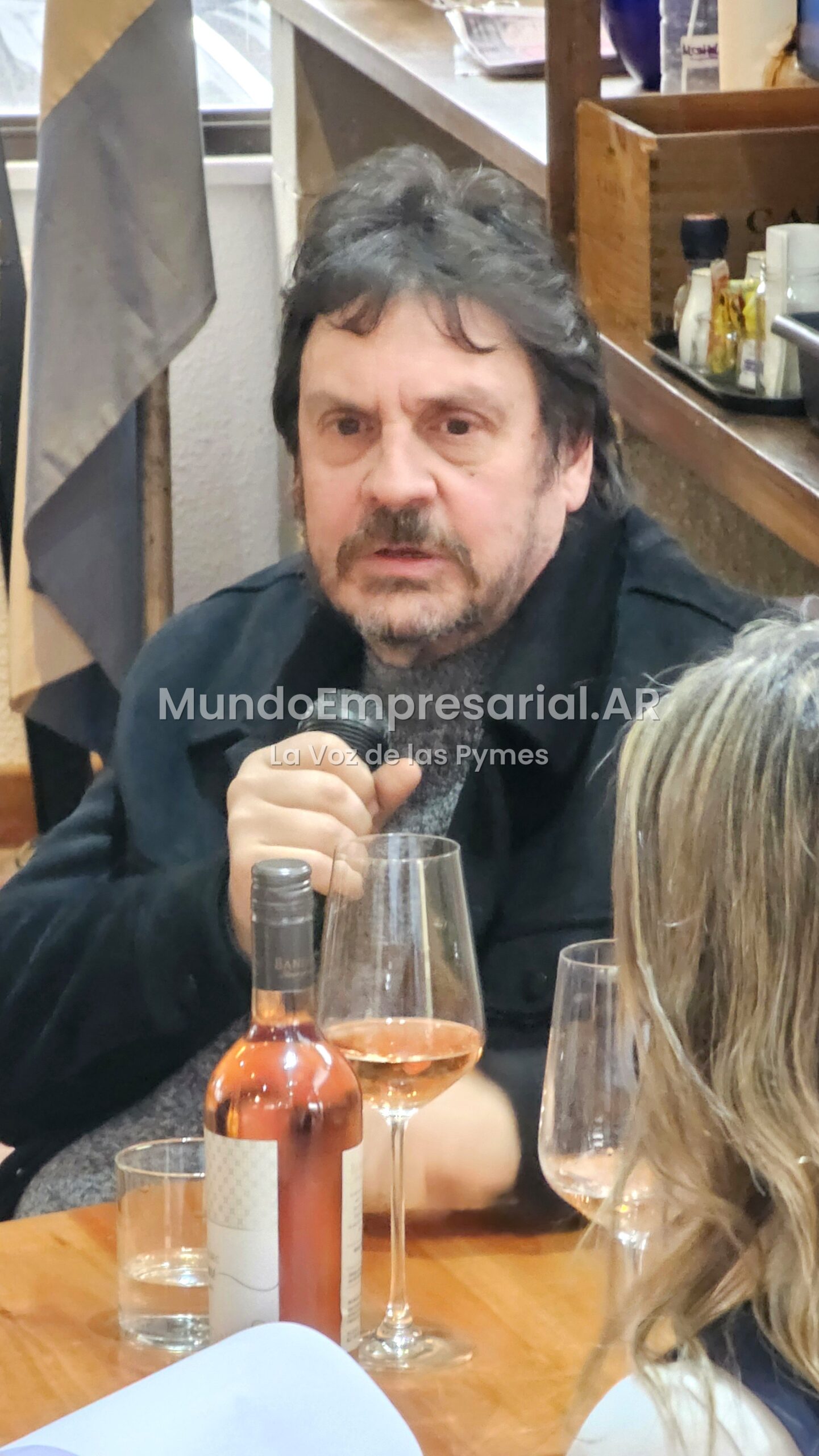 Felipe Pigna con el vino en el cierre de la charla